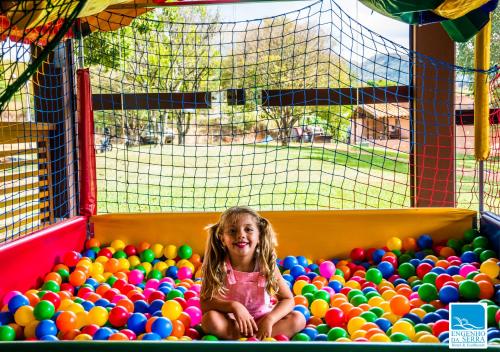 a little girl sitting in a pile of balls at Engenho da Serra Hotel EcoResort in Capitólio