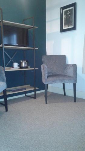 a living room with a chair and a shelf at Hotel Norg in Norg