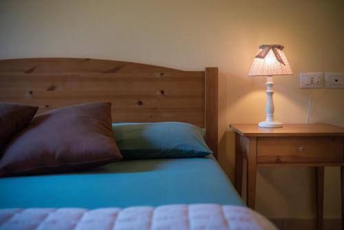 a bedroom with a bed with a lamp on a night stand at Badia Agriturismo in La Torraccia