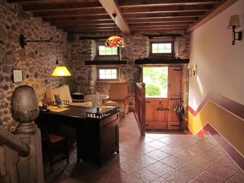 a living room with a piano in a stone building at Casa Os Carballás in Merille