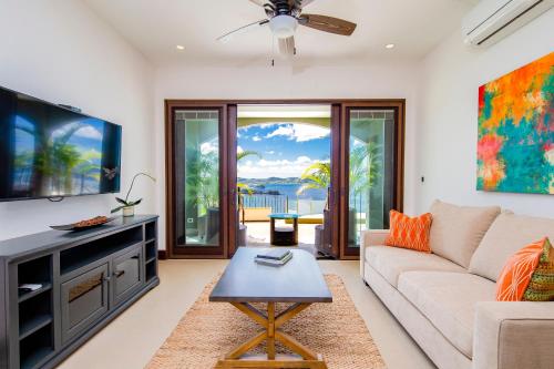 a living room with a couch and a tv at 360 Splendor Del Pacifico Residences in Playa Flamingo