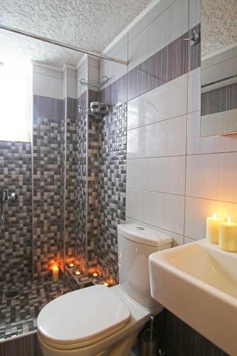 a bathroom with a toilet and a sink and candles at Anemi Apartments in Armenistis