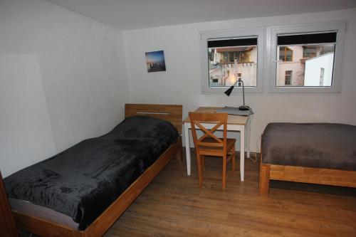 a bedroom with two beds and a desk and a table at Ferienwohnung Eport in Bendorf