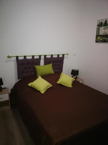 a bedroom with a large bed with two yellow pillows at lupin in Rochefort
