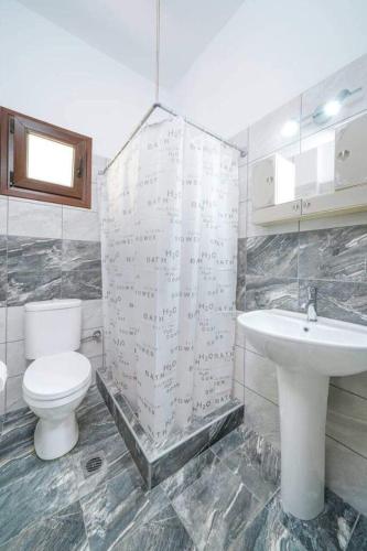 a bathroom with a toilet and a sink at Sevastiani’s Apartments in Skala Kallirachis