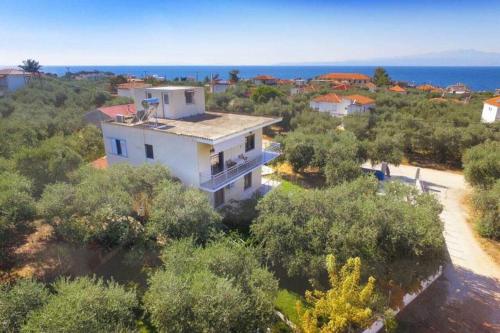 uma vista aérea de uma casa branca nas árvores em Sevastiani’s Apartments em Skala Kallirachis