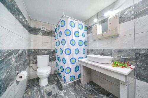 uma casa de banho com um WC, um lavatório e um chuveiro em Sevastiani’s Apartments em Skala Kallirachis