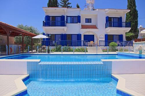 a villa with a swimming pool in front of a house at Villa Mandola Rosa in Prodhromi