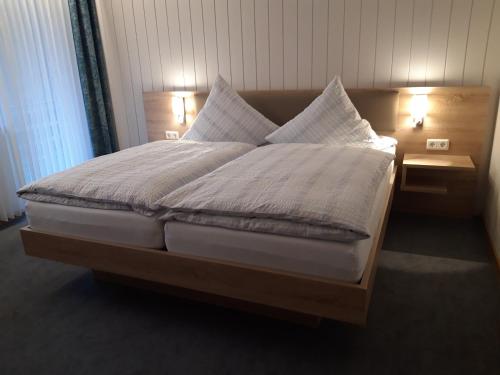 a bed with white sheets and pillows on it at Pension Ferienwohnungen Rosenschlösschen in Willingen