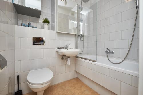 a bathroom with a toilet and a sink and a shower at Noctis Apartment Pańska II in Warsaw