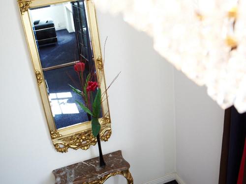 a mirror on a wall with a vase of flowers at Hotell Boras, BW Signature Collection in Borås