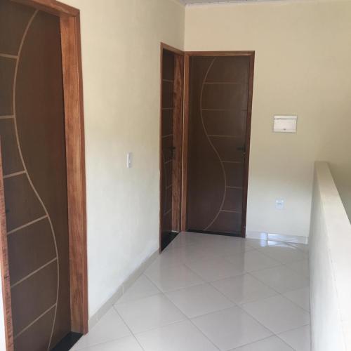 a hallway with two doors and a tile floor at Hospedaria Casa da Lia in Mucugê