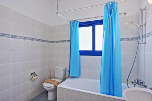 a bathroom with a tub and a toilet and a sink at Villa Mandola Rosa in Prodhromi