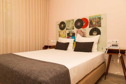 a bedroom with a large white bed with black pillows at Aires da Serra Hotel in Torres Novas