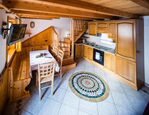 una cocina con mesa y una cocina con armarios de madera. en Appartamenti Touring, en Livigno