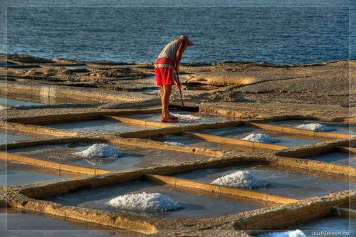 a man standing on steps near the water at Sunset Seaview Accommodation in Marsalforn