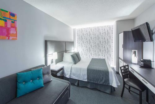 a hotel room with a bed and a couch at Travelodge by Wyndham Montreal Centre in Montréal