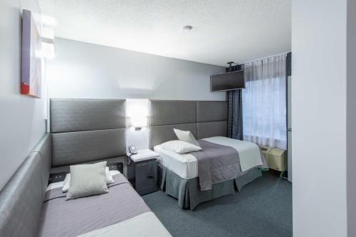 a hotel room with two beds and a window at Travelodge by Wyndham Montreal Centre in Montréal