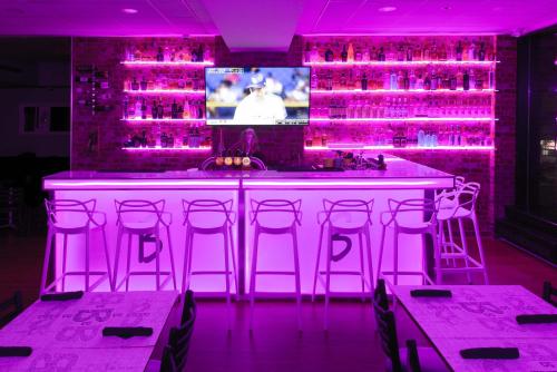 a bar with pink lights and a tv in a room at Travelodge by Wyndham Montreal Centre in Montréal