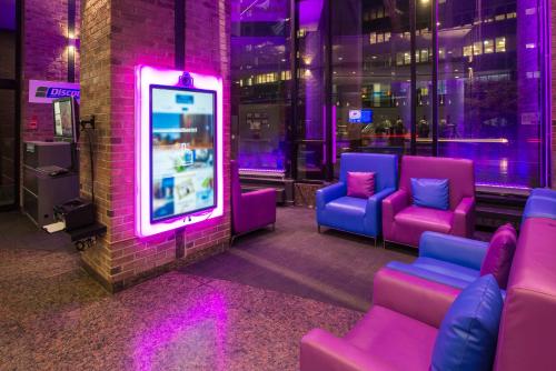 a room with purple chairs and a video game at Travelodge by Wyndham Montreal Centre in Montréal