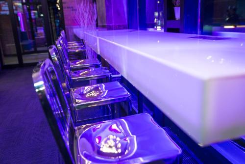 a row of purple chairs lined up at a bar at Travelodge by Wyndham Montreal Centre in Montréal