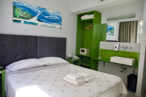 - une chambre avec un lit et des serviettes dans l'établissement America Del Sur Hostel Buenos Aires, à Buenos Aires