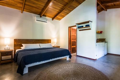 Schlafzimmer mit einem Bett mit blauer Tagesdecke in der Unterkunft The Sunset Shack in Nosara