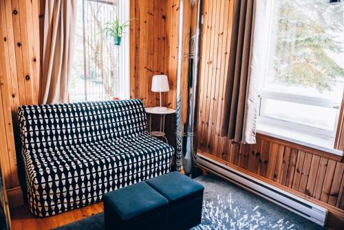a room with a couch and a chair and a window at Gîte TerreCiel in Baie-Saint-Paul