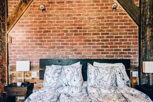 a bedroom with a brick wall and a bed with pillows at Gîte TerreCiel in Baie-Saint-Paul