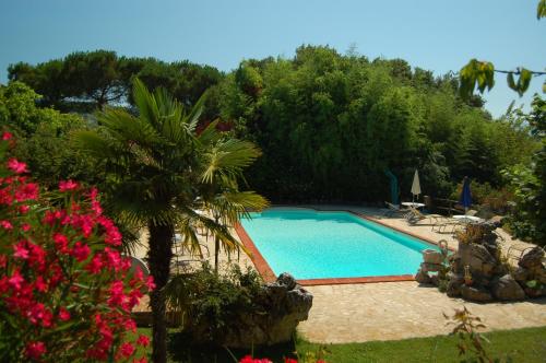 una piscina in un cortile con alberi e fiori di Agriturismo Casale Dei Frontini a San Terenziano