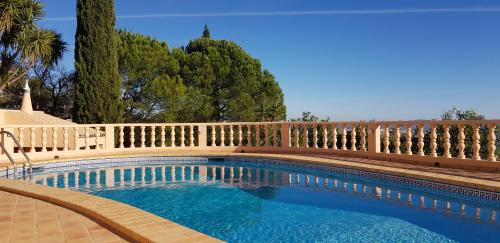 a swimming pool with a wooden fence around it at Villa Quinta da Violeta in Loulé