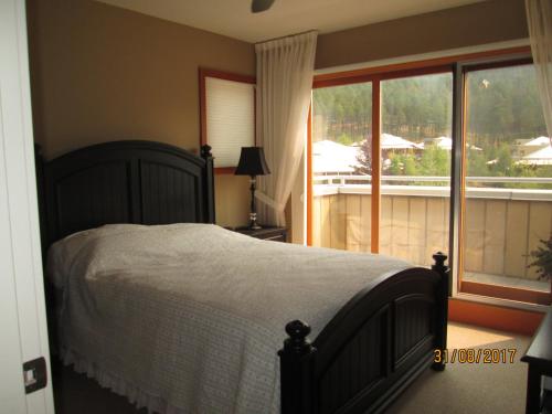 a bedroom with a bed and a large window at OUTBACK,Lakeside Vacation Home Resort in Vernon