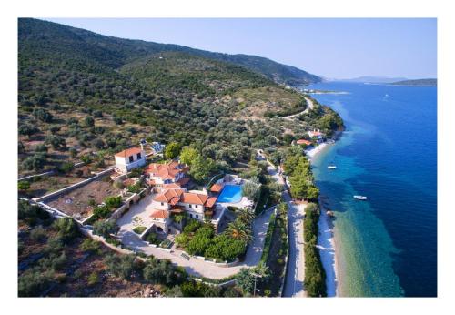 an aerial view of a house on a hill next to the ocean at Alonissos beach villa 5 steps away from the sea in Kalamakia