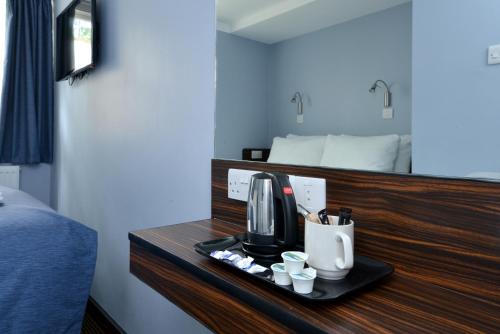 a tray with a coffee maker on a counter in a room at Angus Hotel in London