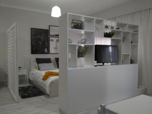 a white room with a bed and a television at Meia Laranja in Almeirim