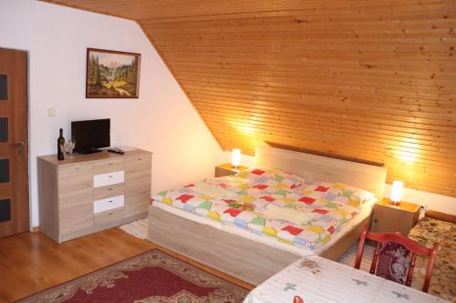 a bedroom with a bed and a wooden wall at Domcek na orave in Habovka