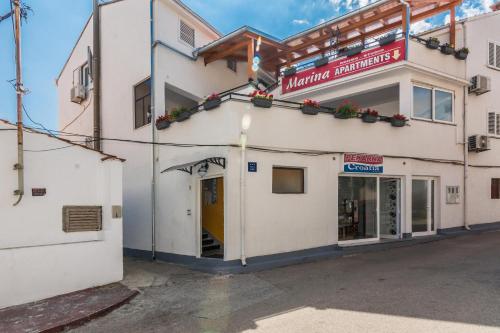 a white building with a sign on it at Apartments Marina in Zadar