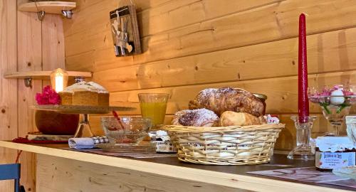 un comptoir avec un panier de pain et d'autres aliments dans l'établissement Ma Roulotte sous les Chênes "la passionnée", à Raon-aux-Bois
