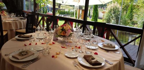 a table with plates and glasses on a white table cloth at 3 Stejari Brasov in Braşov