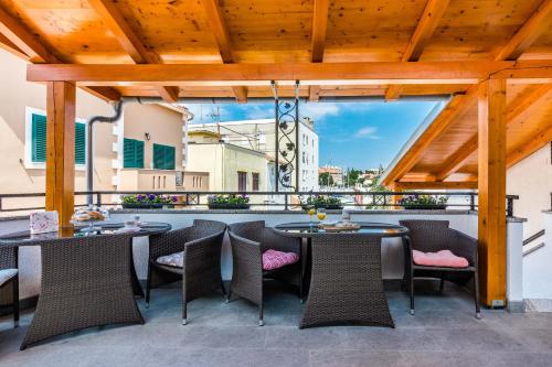 a patio with tables and chairs on a balcony at Apartments Marina in Zadar