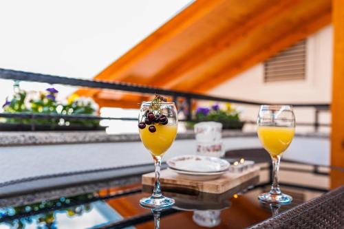 deux verres de jus d'orange et de raisins sur une table dans l'établissement Apartments Marina, à Zadar