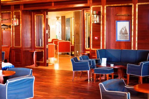 a restaurant with blue chairs and tables in a room at Regency Hotel & Spa in Monastir