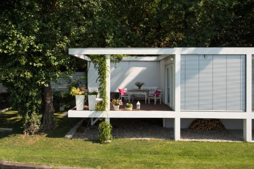 a white shed with a pergola in a yard at Marina Hausboote und Seelodge in Berlin