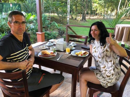 Un hombre y una mujer sentados en una mesa comiendo comida en La Foresta Nature Resort, en Quepos