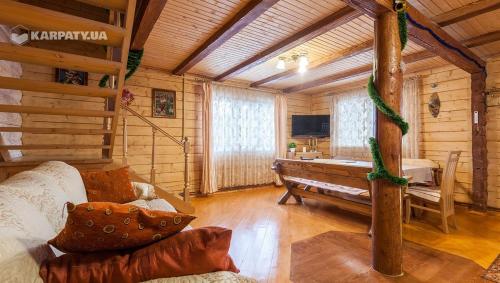 una sala de estar con sofá y bañera en una cabaña en У Гриніва, en Polyanitsa Popovichovska