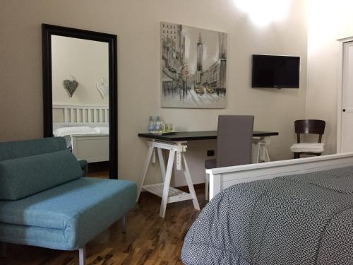 a bedroom with a bed and a desk and a mirror at B&B Martina in Assemini