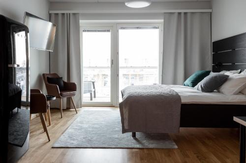sypialnia z łóżkiem i dużym oknem w obiekcie Apartment Station w mieście Oulu