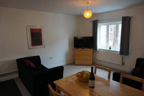 a living room with a table with a bottle of wine at The Coach House in Bristol