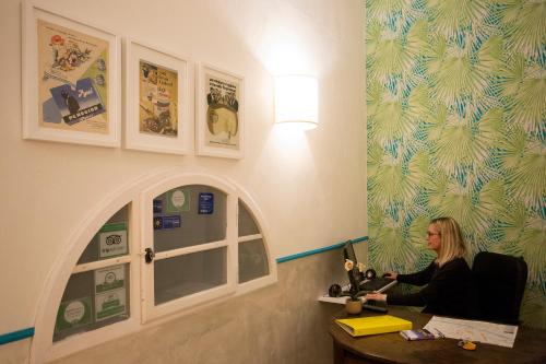 a woman sitting in front of a window looking at her cell phone at Hotel Bencidormi in Florence