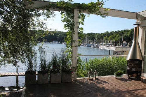 a pergola with a view of a river at Marina Hausboote und Seelodge in Berlin